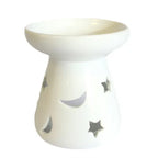 A white, glossy ceramic oil warmer featuring an intricate star and moon design. The piece has a wide bowl on top for essential oils or wax melts and a sturdy base with cutouts that allow for the placement of a tea light candle. The oil warmer's smooth, clean lines and celestial motif make it a beautiful and functional piece of home decor. This high-resolution, front-facing product shot against a crisp white background. 