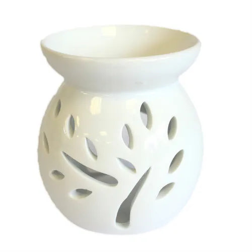 A beautiful, white ceramic oil warmer with a glossy finish, featuring a detailed cutout of a tree with leaves on its side. This stylish, modern aromatherapy essential oil diffuser has a top bowl for holding wax melts or oils and a base with a large opening to accommodate a tea light candle. The intricate tree design allows the candle's light to cast elegant shadows, creating a tranquil and relaxing ambiance. This product is ideal for home decor, meditation, and gifting.Shot against a clean white background.