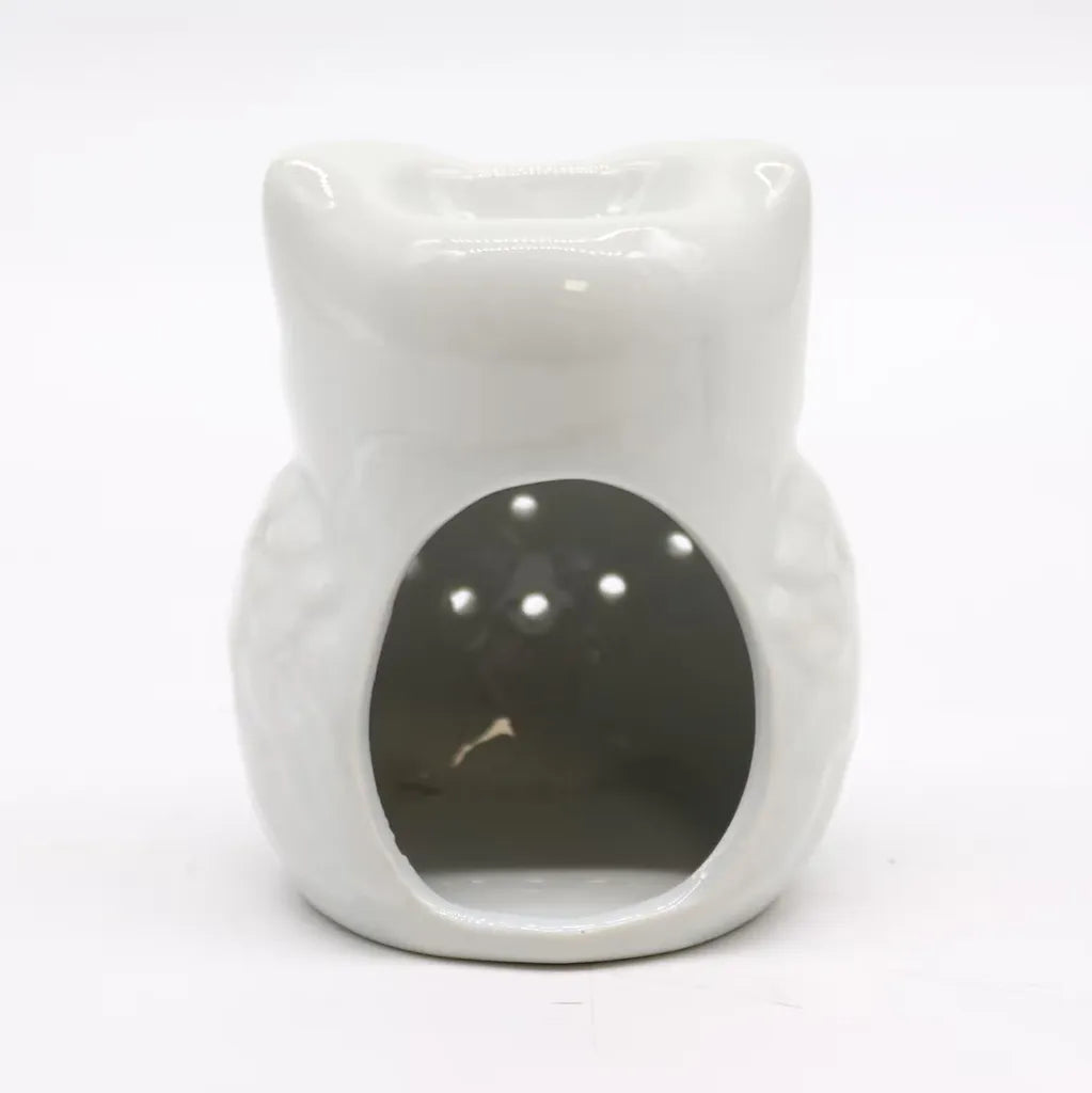 A full, back-facing product shot of a cute, white ceramic owl essential oil diffuser against a pure white background. The owl has a simplified, rounded shape with a glossy glaze. There is a large oval opening on the back for easy access to place a tea light candle. The top of the owl's head forms a deep dish for essential oils or wax melts. 