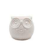 A white, glossy ceramic owl oil burner with a rounded, plump body and a textured feather pattern. The owl has large, circular, textured eyes with small cutouts below them for ventilation and light. The top of the owl's head serves as a bowl for essential oils or wax melts. The product is displayed on a white background.