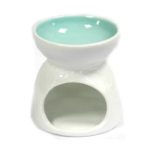 A beautiful white ceramic oil burner with a contrasting teal-colored bowl. The round, smooth body features a subtle floral design and a large circular opening on the side for inserting a tea light candle. The unique two-tone design adds a modern and stylish flair. This product functions as an essential oil diffuser and wax melt warmer, perfect for creating a relaxing and fragrant atmosphere.