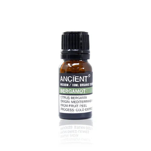 A small, 10ml amber glass bottle of Ancient Wisdom Organic Bergamot essential oil. The bottle has a black cap and a black label with a light green band. The label lists product details including the Latin name, origin, and distillation process. The bottle is photographed against a clean white background.