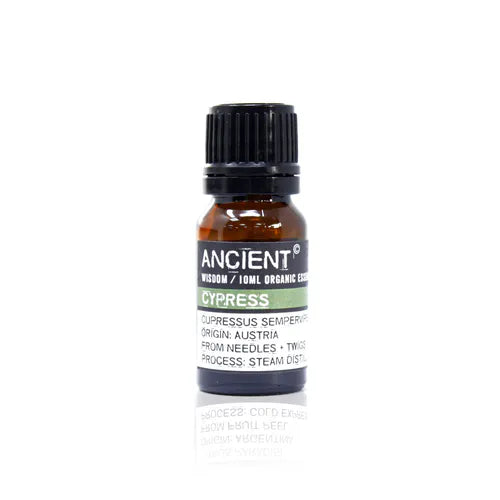 A small, 10ml amber glass bottle of Ancient Wisdom Organic Cypress essential oil. The bottle has a black cap and a black label with a light green band. The label lists product details including the Latin name, origin, and distillation process. The bottle is photographed against a clean white background.