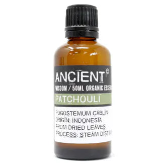Amber glass bottle labeled 'Ancient Wisdom Organic Essential Oil Patchouli 50ml,' origin Indonesia, made from dried leaves, steam distilled.
