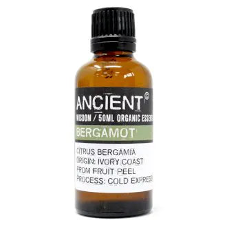 Amber glass bottle labeled 'Ancient Wisdom Organic Essential Oil Bergamot 50ml,' origin Ivory Coast, made from fruit peel, cold expressed.