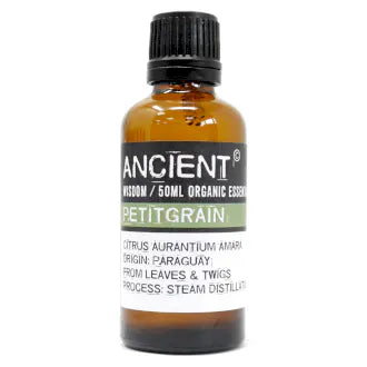 Amber glass bottle labeled 'Ancient Wisdom Organic Essential Oil Petitgrain 50ml,' origin Paraguay, made from leaves and twigs, steam distilled.