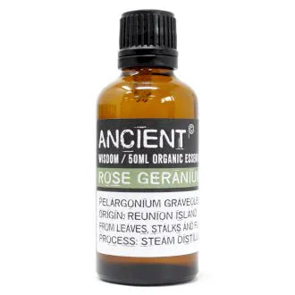 Amber glass bottle labeled 'Ancient Wisdom Organic Essential Oil Rose Geranium 50ml,' origin Reunion Island, made from leaves, stalks, and flowers, steam distilled.