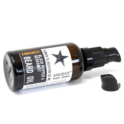 A brown 50ml glass bottle of Ancient Wisdom Roman Gladiator Beard Oil lying on its side on a white background. The bottle's black pump dispenser is visible, and the black cap is placed next to it. The label details the "Black Pepper & Bergamot" scent.