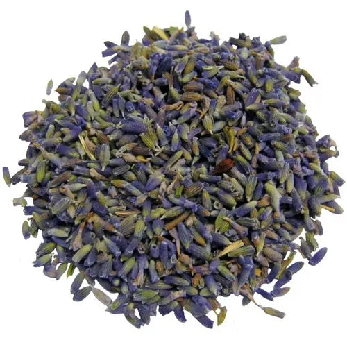 A pile of dried, loose lavender buds shown on a clean white background. The mound consists of small, elongated blossoms in shades of purple, blue, and dusty gray, highlighting the natural texture and vibrant color of the herbal product.