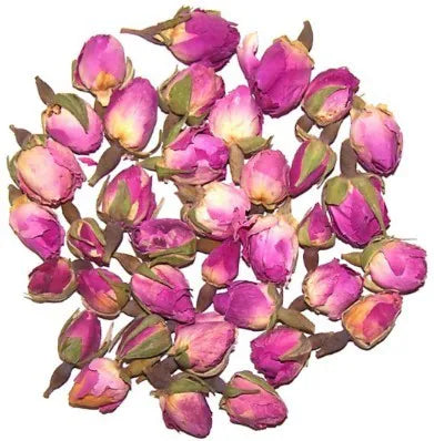 A collection of whole, dried rosebuds in shades of bright fuchsia and deep pink, arranged in a circular pattern on a pure white background. The image highlights the closed, bulbous shape of the buds and their delicate texture.