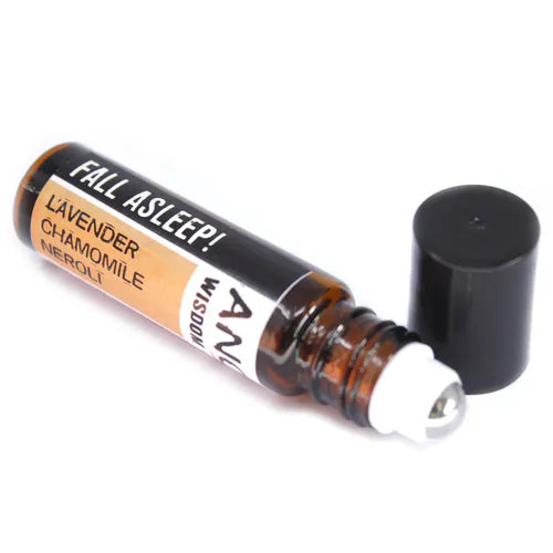 Open roll-on essential oil blend labeled 'Fall Asleep!' with lavender, chamomile, and neroli. Brown glass bottle with roller ball and black cap beside it.