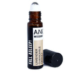 Roll-on essential oil blend labeled 'Fall Asleep!' with lavender, chamomile, and neroli. Brown glass bottle with roller ball and black cap lying next to it.