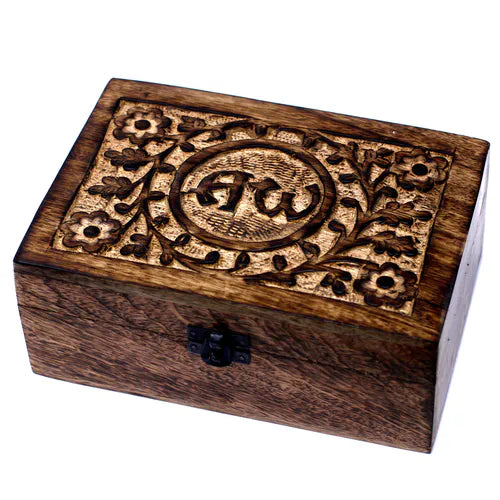 dark brown wooden box with a lid featuring a carved spiritual design. The intricate pattern includes a central circular medallion with the "AW" symbol, surrounded by stylized flowers and leaves. A small black metal clasp is on the front, and the product is shot on a white background.