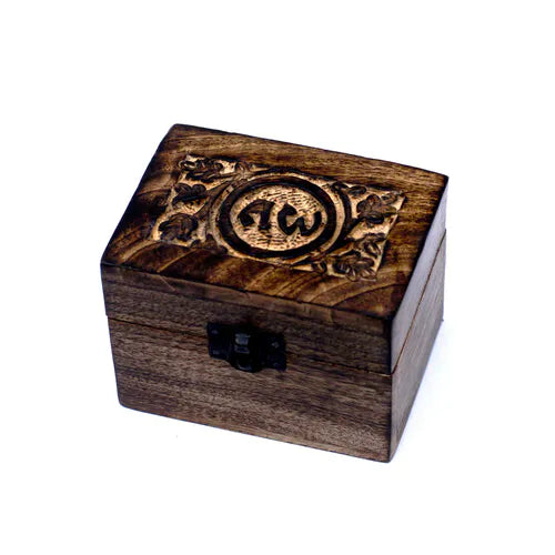 A small, square wooden box with a dark finish. The lid features an intricately carved spiritual pattern with the "AW" symbol in a central circular medallion, surrounded by stylized flowers and leaves. A small black metal clasp is on the front, and the product is photographed on a white background.